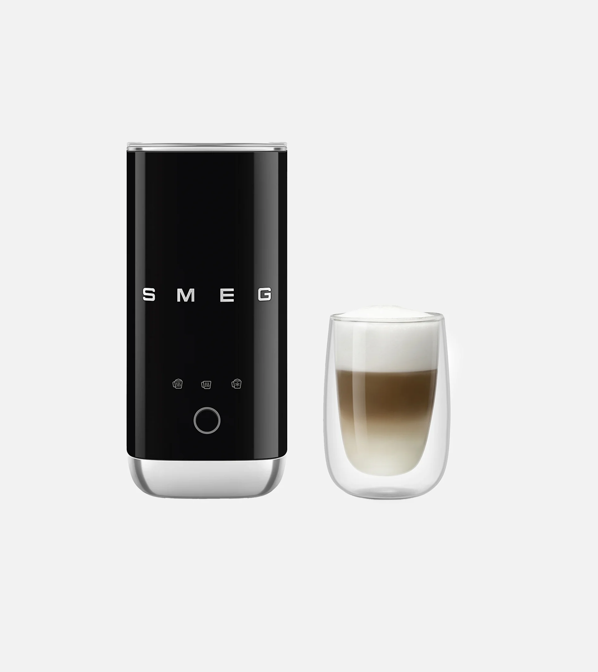 Sort Smeg melkeskummer ved siden av et glass lagdelt kaffe med skum.