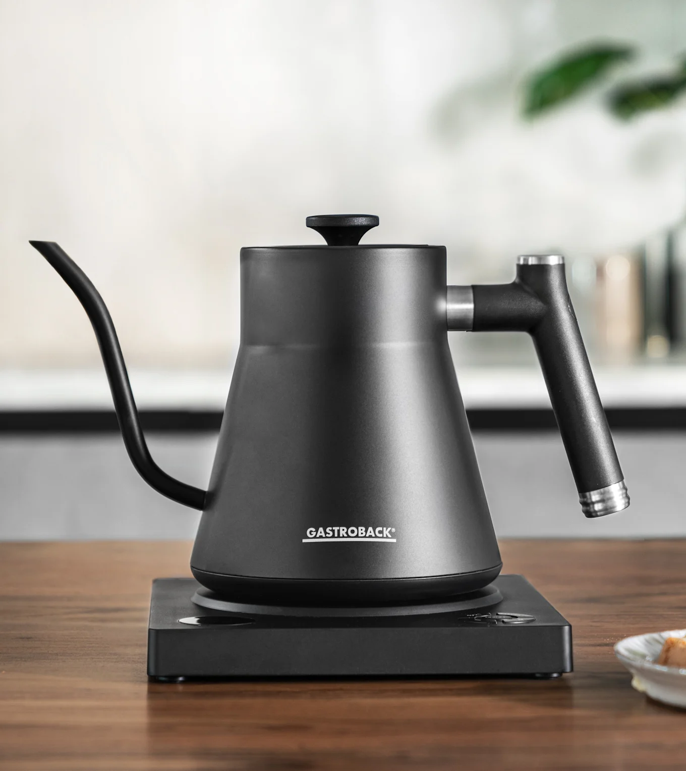 Matt sort pour-over vannkoker med svanehals tut på en matchende elektrisk base.