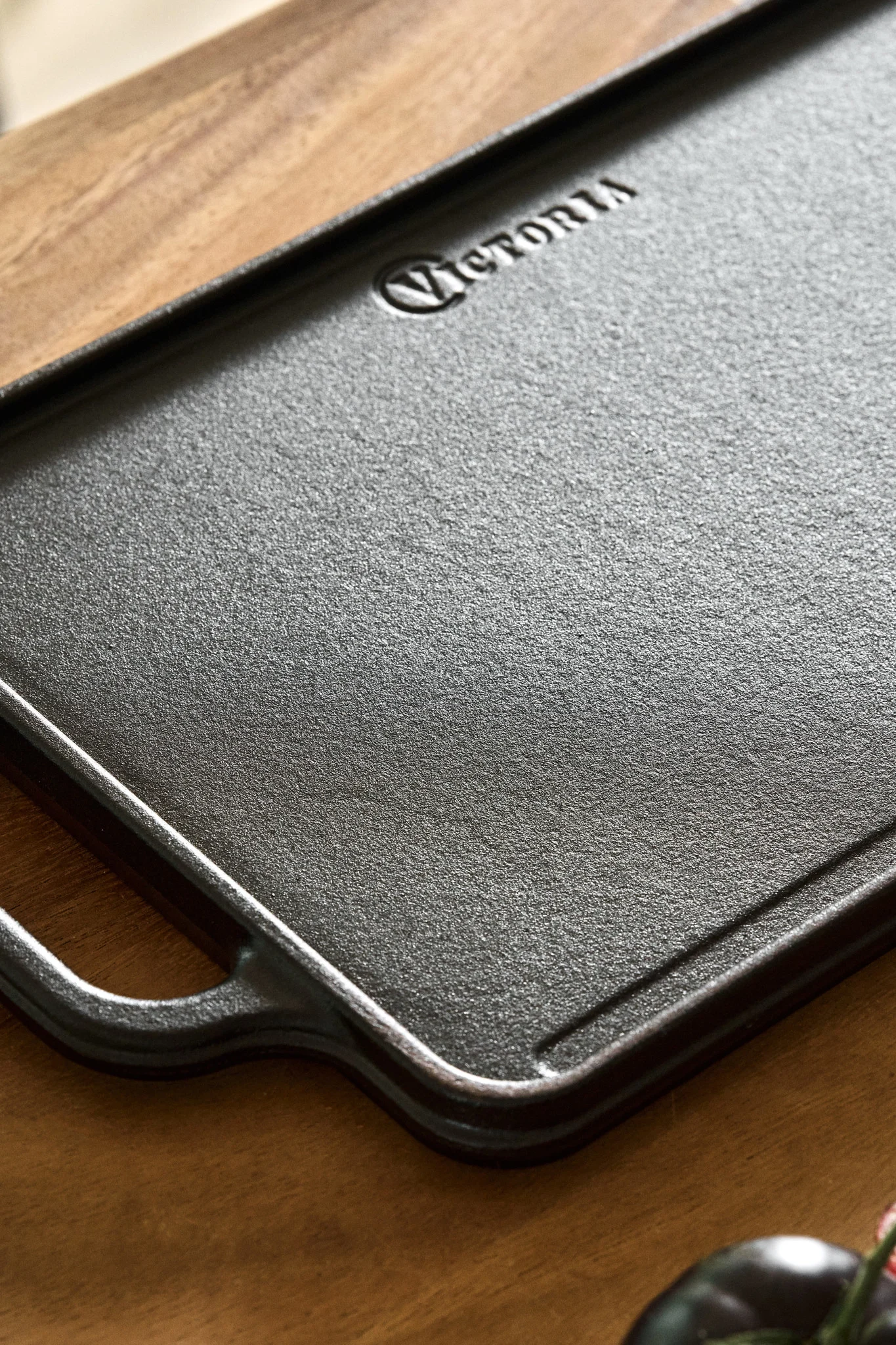 En vendbar stekeplate i støpejern på en kjøkkenbenk av tre.